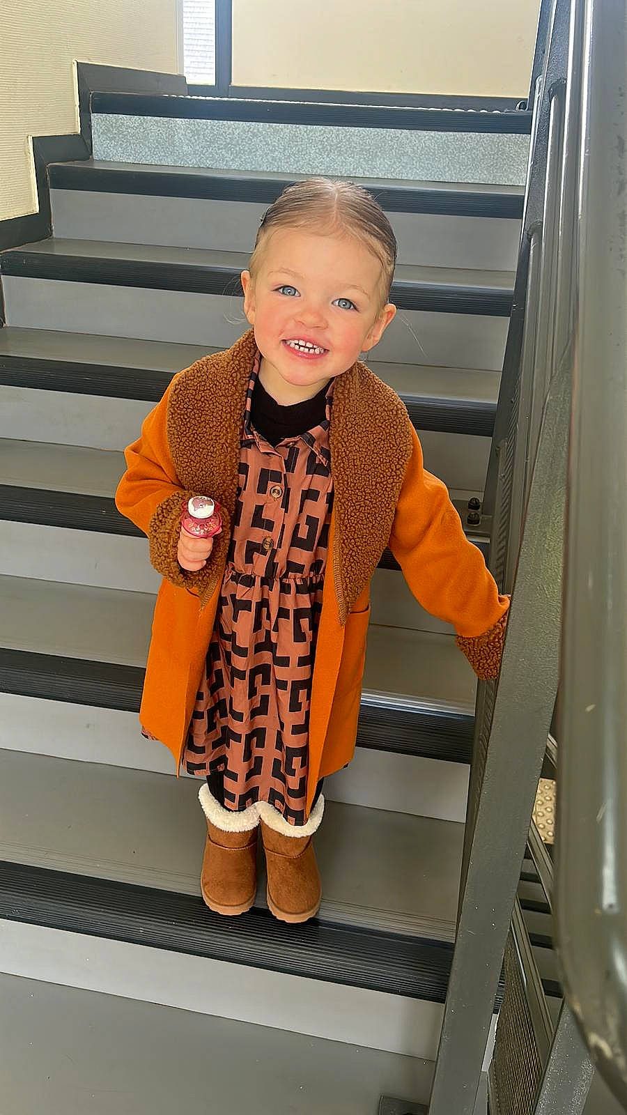 Lya participe au concours pour gagner de l'argent avec cette photo : baby_toddler_clothing, blazer, eyewear, face, fashion, fashion_accessory, fashion_design, flooring, formal_wear, human_leg, joy, knee, orange, outerwear, pattern, person, sleeve, smile, stairs, t_shirt