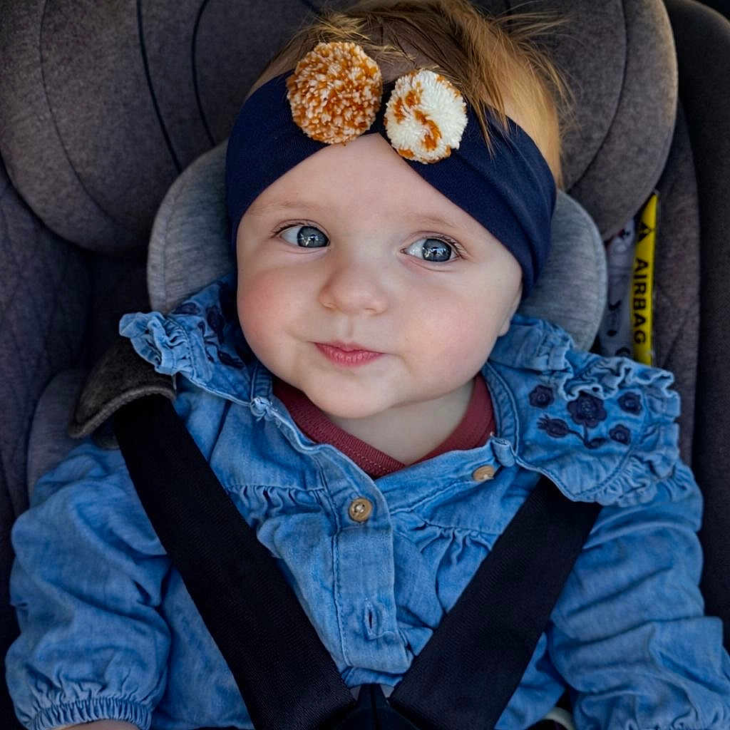 Maena participe au concours pour gagner de l'argent avec cette photo : baby, child, car_seat, headband, pom_poms, denim_shirt, seatbelt, blue_eyes, infant, cute, smile, clothing, sitting, car_interior, young_child, portrait, safety_harness, casual, happy, indoors