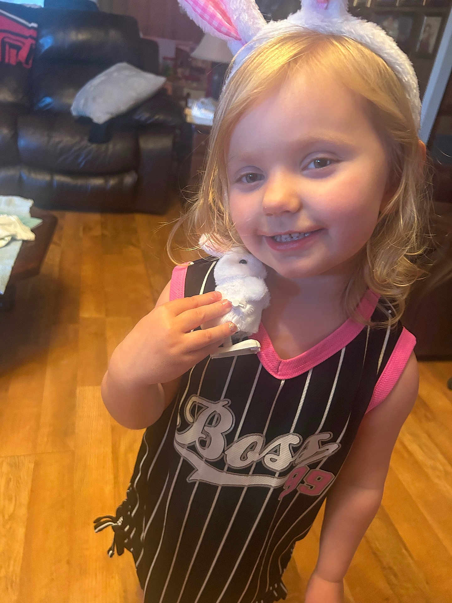 Arrie joined the competition — help win amazing prizes! child, toddler, girl, smiling, bunny_ears, plush_toy, living_room, couch, hardwood_floor, portrait, clothing, stripes, pink, blonde_hair, toy, indoor, happy, face, eyes, furniture