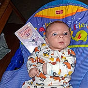 Mateo joined the competition — help win amazing prizes! baby, infant, onesie, fisher_price, chair, indoor, milestone_card, 8_weeks_old, wide_eyes, surprised, curious, colorful, patterned_clothing, cute, child, person, seated, carpet, wooden_furniture, photography