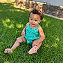 toddler, child, grass, outdoor, sunlight, green, smiling, curly_hair, onesie, baby, happy, sitting, nature, daylight, skin, foot, portrait, casual, playful, young