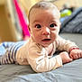 Joshua is registered to the contest to win money with this photo: baby, infant, bed, lying_down, face, wide_eyes, curious, indoors, soft_focus, clothing, long_sleeves, hands, skin, head, portrait, child, cute, young, person, cozy