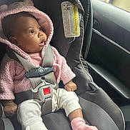 Carter is registered to the contest to win money with this photo: baby, car_seat, pink_hoodie, safety_harness, child, infant, car_interior, window, curious, seatbelt, clothing, person, sitting, sock, blanket, indoors, seat, headwear, fuzzy, young_child