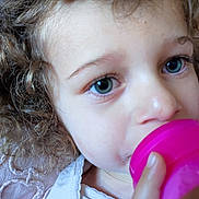Yness participe au concours pour gagner de l'argent avec cette photo : baby, blue_eyes, child, close_up, clothing, curly_hair, cute, drinking, expression, face, hand, hydration, indoor, innocent, person, pink_cup, portrait, skin, toddler, young