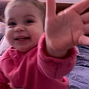 Livina a rejoint le concours — aidez-le/la à gagner de superbes lots ! child, toddler, baby, smiling, reaching_hand, hand, pink_sweater, close_up, indoor, bed, blanket, pillow, hair_bow, happy, motion_blur, portrait, toy, soft_lighting, headboard, playful