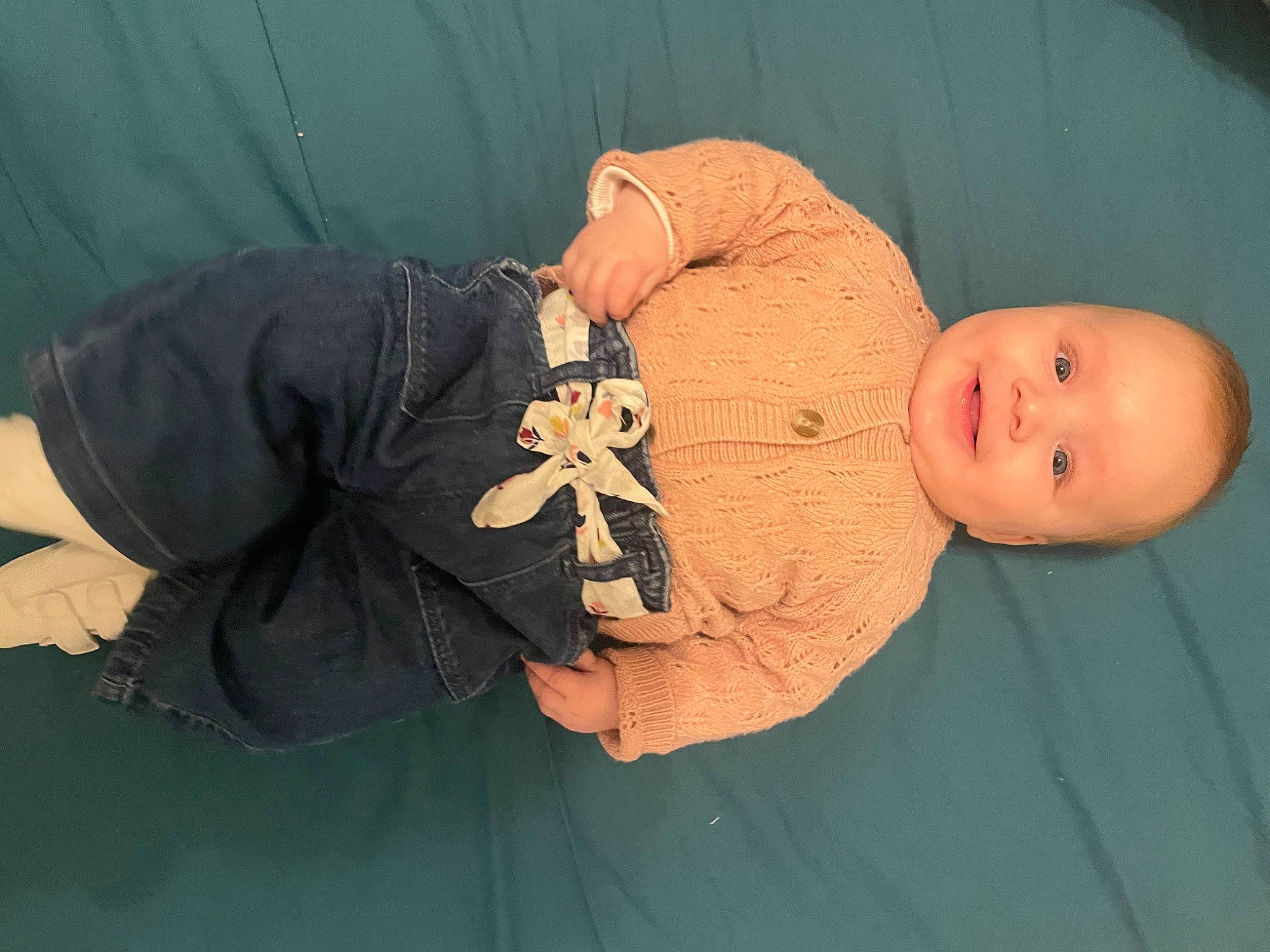 Ellie participe au concours pour gagner de l'argent avec cette photo : abdomen, baby, baby_products, baby_toddler_clothing, cheek, child, comfort, elbow, finger, human_body, human_leg, joy, knee, mouth, person, room, sitting, skin, sleeve, smile