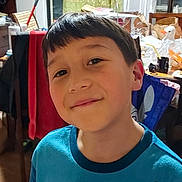 Jesse joined the competition — help win amazing prizes! child, boy, smile, indoor, portrait, face, short_hair, blue_shirt, cluttered_background, furniture, toy, household_items, curtain, table, chair, person, happy, casual, home, decor