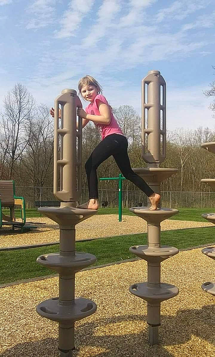 Emilie is registered to the contest to win money with this photo: city, leg, outdoor_play_equipment, park, person, play, playground, public_space, recreation, tree
