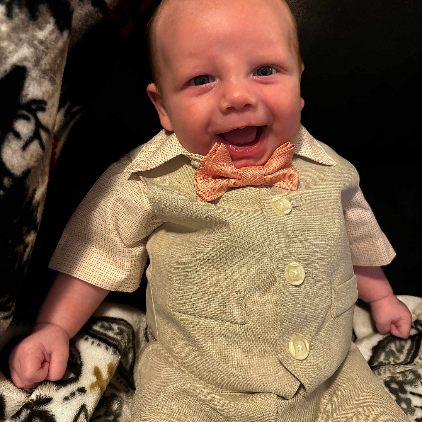 Logan is registered to the contest to win money with this photo: accessories, baby, babylaughing, bodypart, clothing, coat, couch, face, formalwear, furniture, happy, head, laughing, pants, person, photography, portrait, shirt, smile, tie