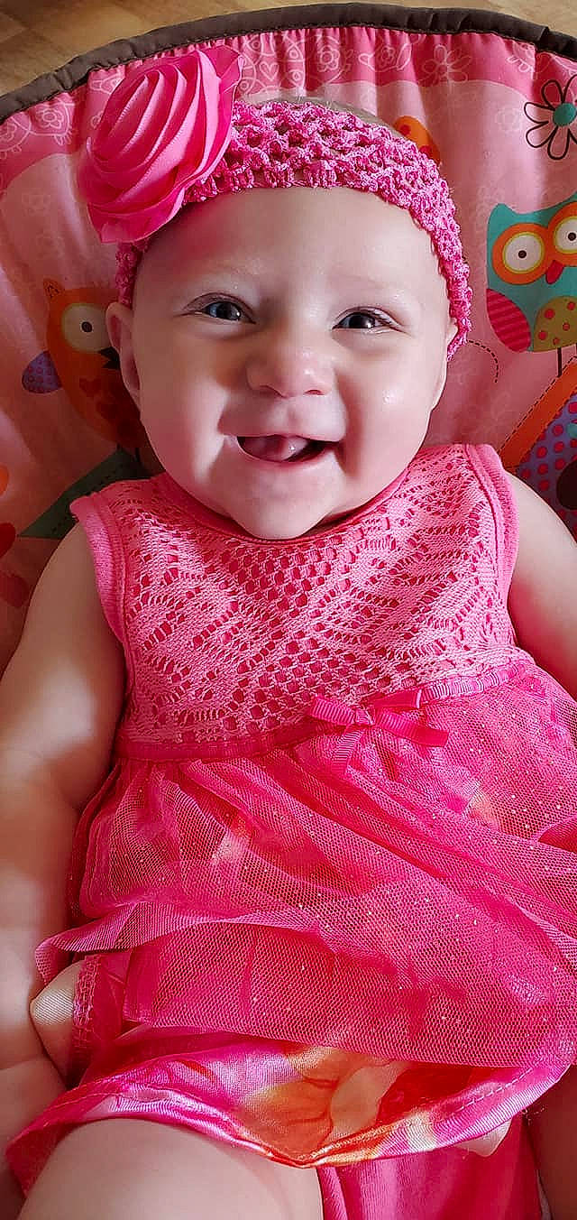 Anastasia is registered to the contest to win money with this photo: baby_toddler_clothing, cap, cheek, chin, dress, embellishment, face, happy, headgear, headwear, iris, lip, neck, outerwear, person, pink, red, skin, sleeve, smile