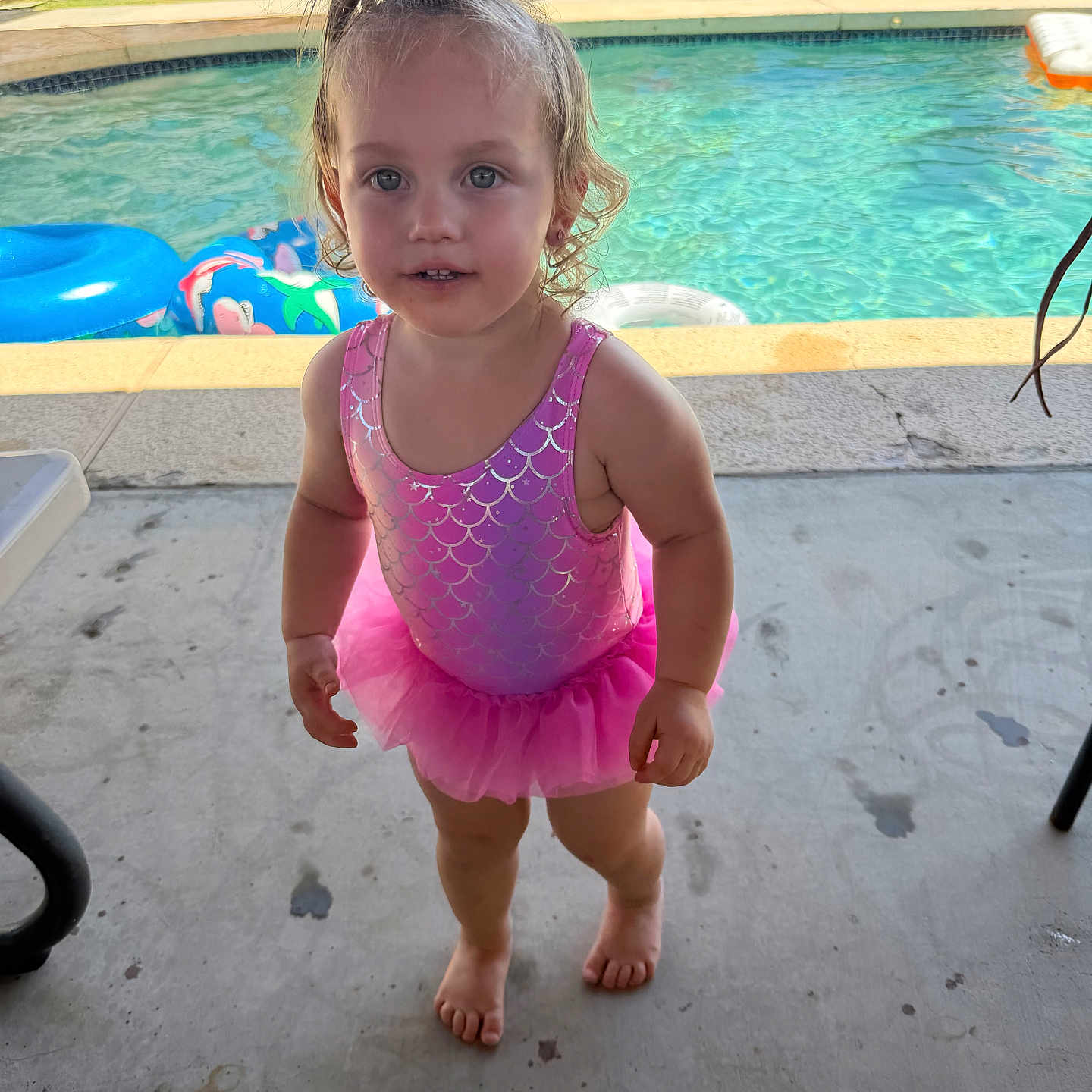 Gianna joined the competition — help win amazing prizes! toddler, child, swimsuit, pink, pool, outdoor, barefoot, concrete, curly_hair, pony_tail, playful, summer, water, floaties, inflatable, backyard, sunny, person, young_child, casual