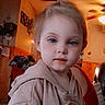 Caroline joined the competition — help win amazing prizes! child, indoor, hoodie, pony_tail, face, person, home, living_room, warm_lighting, ceiling_fan, wood_paneling, casual_clothing, portrait, young_child, curious, seated, relaxed, cozy, cute, casual