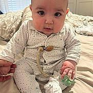 Asim participe au concours pour gagner de l'argent avec cette photo : baby, infant, onesie, pacifier, hand_holding, bed, bedroom, blanket, cute, chubby_cheeks, sitting, clothing, person, face, indoor, young_child, soft_lighting, sleepwear, expression, curious