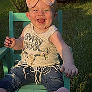 Ivy joined the competition — help win amazing prizes! baby, child, smiling, happy, outdoor, grass, chair, bow, headband, tank_top, denim, pants, shoes, tongue_out, sunlight, greenery, person, portrait, casual_clothing, cute