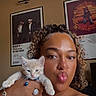 Stormi And Cheeto joined the competition — help win amazing prizes! person, kitten, cat, indoor, selfie, curly_hair, jewelry, bracelet, ring, nose_ring, blue_collar, bell, poster, wall_art, beige_wall, portrait, cute, pet, smile, casual