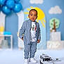 toddler, child, blue_outfit, checkered_clothing, white_shoes, toy_car, balloons, sun, clouds, tree, indoor, portrait, fashion, cute, standing, playful_background, photography, smiling, young_child, casual