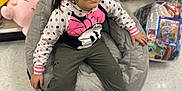 Rosalie Haze is registered to the contest to win money with this photo: bean_bag, casual, child, clothing, colorful, crocs, floor, footwear, girl, happy, hoodie, indoor, packaged_items, plush_toys, polka_dot, relaxed, sitting, smiling, store_aisle, toy_store