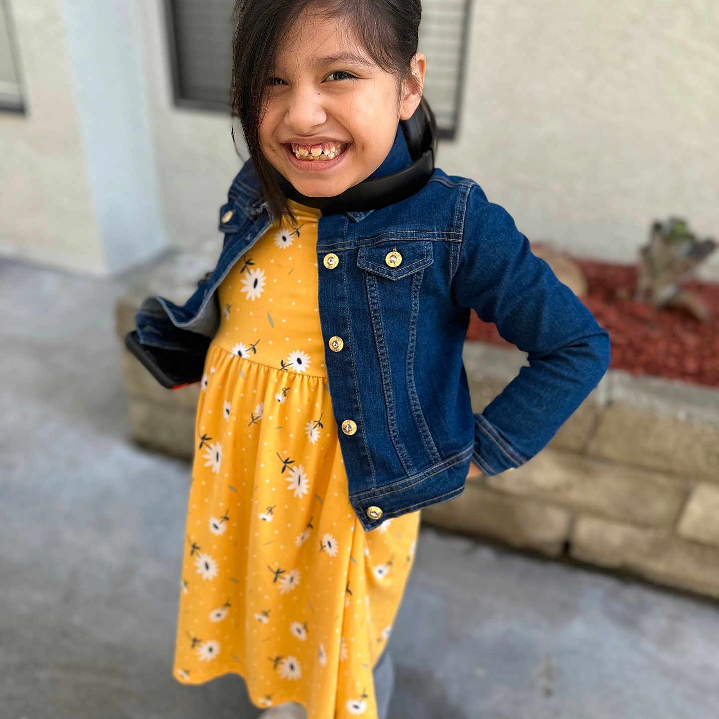 Rosalie Haze joined the competition — help win amazing prizes! casual_clothing, child, concrete_floor, denim_jacket, face, flower_pattern, girl, happy, joyful, long_hair, natural_light, outdoor, portrait, posing, smiling, sneakers, standing, wall, window, yellow_dress