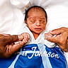 Amir is registered to the contest to win money with this photo: newborn, baby, infant, hands, tattoo, blanket, sleeping, person, white_background, closeup, gentle, skin, portrait, resting, human, cute, small, peaceful, holding, toddler