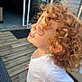 Ylana a rejoint le concours — aidez-le/la à gagner de superbes lots ! child, toddler, curly_hair, smiling, white_shirt, outdoor, wooden_deck, house, door, happiness, joy, side_profile, person, daylight, playful, casual_clothing, tattoo, hand, expression, fun