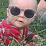 Levi is registered to the contest to win money with this photo: baby, sunglasses, grass, red_clothing, outdoor, face, child, curious_expression, tattoo, person, infant, casual, nature, headwear, eyewear, summer, cute, fashion, portrait, relaxed