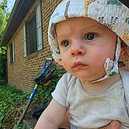 Levi joined the competition — help win amazing prizes! baby, child, hat, outdoor, brick_wall, garden, person, hand, summer, cute, portrait, serious, sunhat, clothing, greenery, daylight, closeup, infant, nature, background