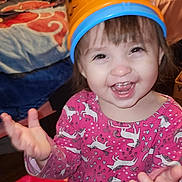 Hayven joined the competition — help win amazing prizes! child, toddler, smiling, happy, pink_dress, unicorn_pattern, bucket_hat, orange_bucket, indoor, bedroom, blanket, furniture, wood_floor, toy, person, face, hands, clothing, playful, cute