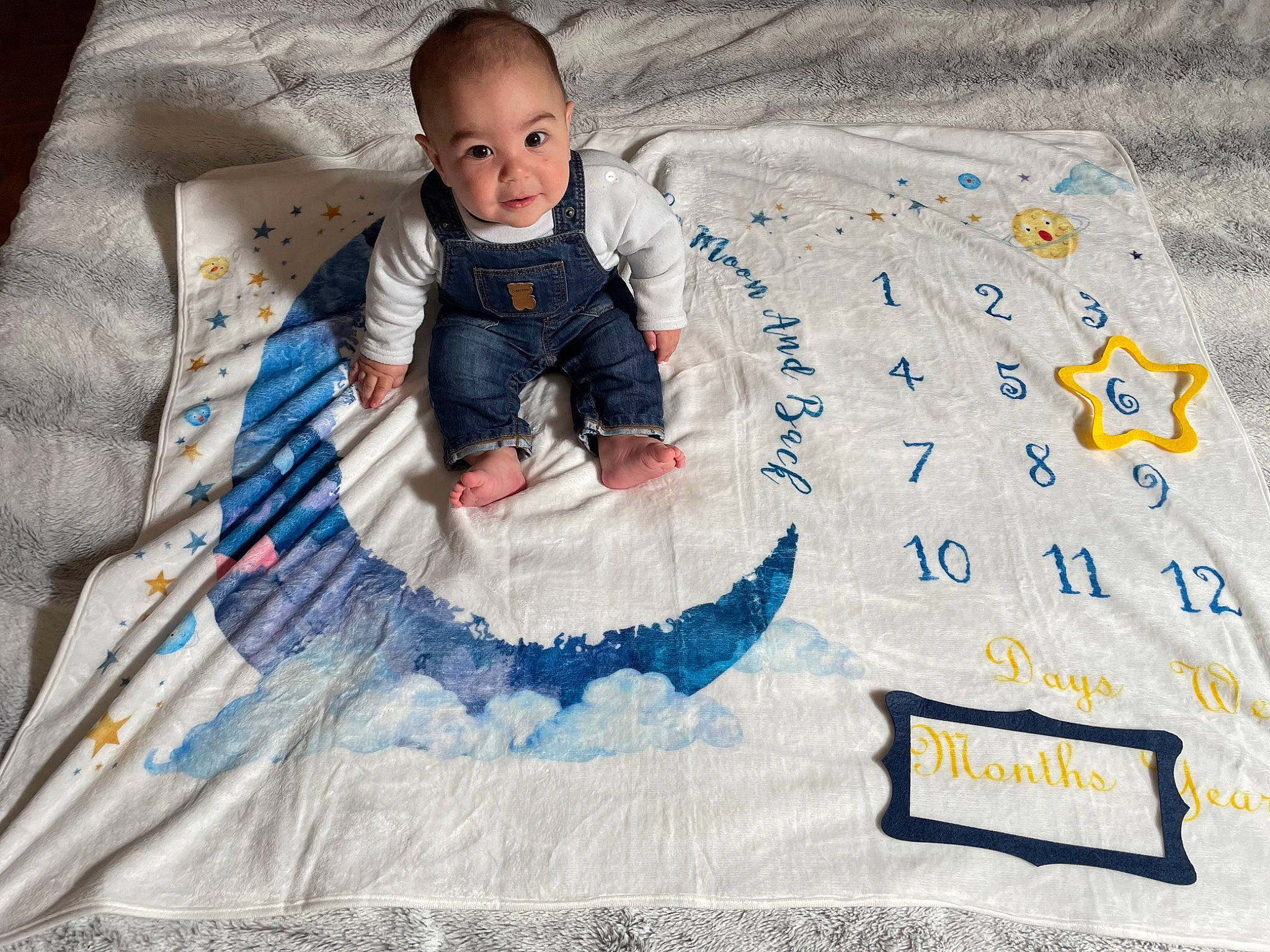 Téo participe au concours pour gagner de l'argent avec cette photo : azure, baby, baby_products, baby_toddler_clothing, child, electric_blue, flooring, font, fun, happy, linens, pattern, person, sitting, sleeve, smile, t_shirt, textile, toddler, winter