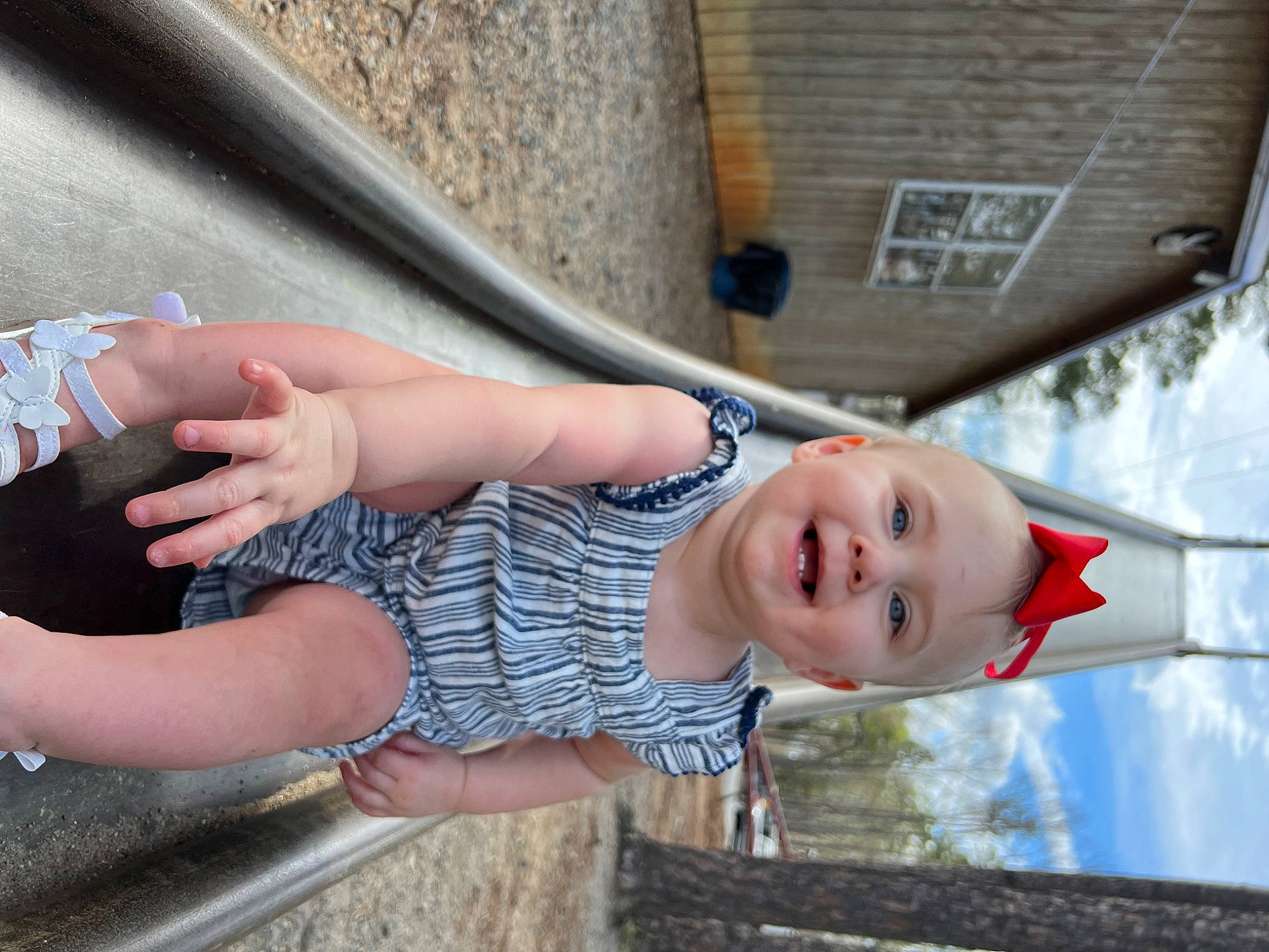 Peyton Mabel is registered to the contest to win money with this photo: barefoot, child, elbow, flip_flops, foot, fun, human_leg, joy, leg, leisure, person, recreation, sandal, sitting, skin, smile, street_fashion, thigh, toddler, tree