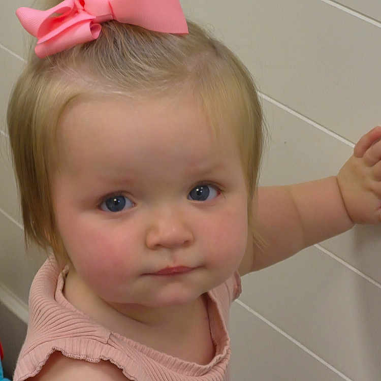 Jasmine joined the competition — help win amazing prizes! toddler, child, girl, pink_bow, blonde_hair, blue_eyes, sleeveless_top, indoor, wall, portrait, cute, baby, looking_at_camera, standing, hand_on_wall, young_child, expression, fashion_accessory, human, person