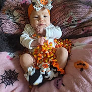 Aurelia is registered to the contest to win money with this photo: baby, blanket, bow, candy_corn, celebration, child, costume, cute, face, halloween, headband, holiday, indoors, infant, person, pink, pumpkin, socks, spider_web, toddler