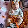 baby, infant, halloween, candy_corn, costume, headband, blanket, sock, pumpkin, ghost, cute, festive, orange, white, black, smile, face, hand, sitting, celebration