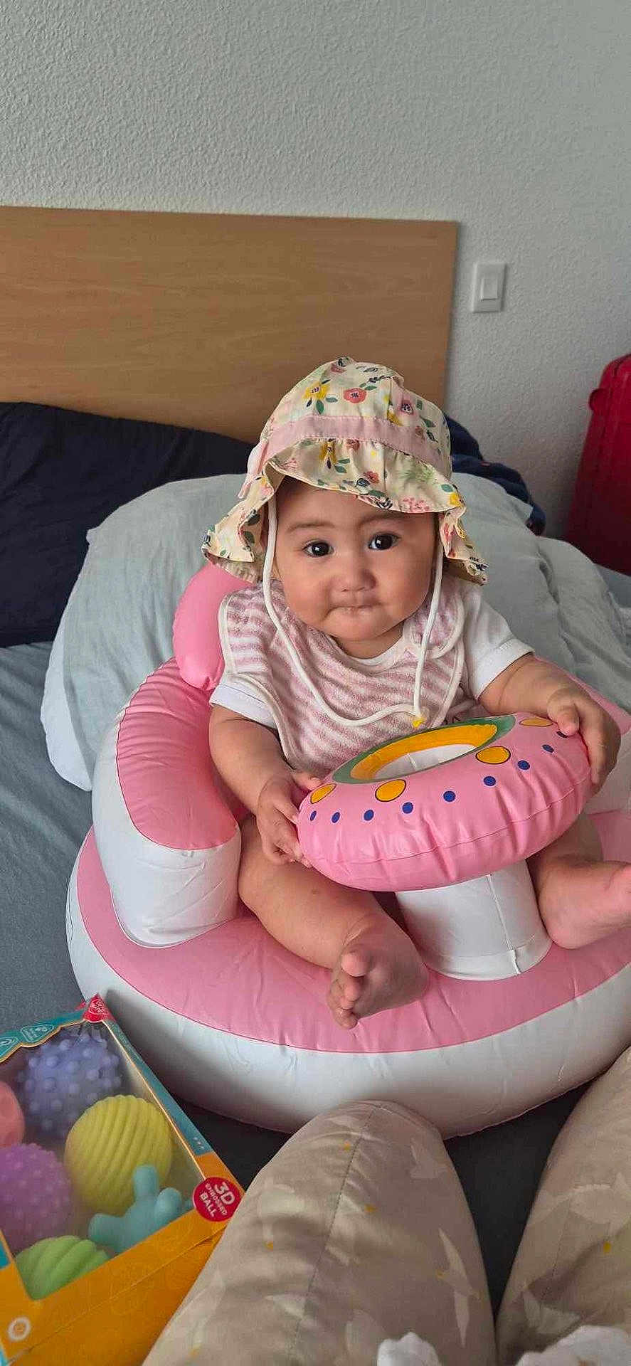 Mataura participe au concours pour gagner de l'argent avec cette photo : baby, infant, hat, pink, inflatable, toy, bed, pillow, child, face, cute, sitting, indoor, clothing, person, play, colorful, smile, comfort, young