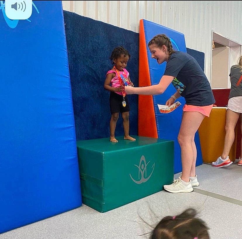 Makiah is registered to the contest to win money with this photo: box, calf, child, competition, electric_blue, fun, human_leg, joy, knee, leg, leisure, person, recreation, room, shoe, shorts, sneakers, sports, sportswear, t_shirt