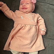 Nelya participe au concours pour gagner de l'argent avec cette photo : baby, child, clothing, couch, cozy, cute, footwear, happy, headband, indoors, infant, legwear, lying_down, person, pink_dress, portrait, relaxed, small_shoes, smiling, soft_fabric