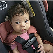 Nevaeh joined the competition — help win amazing prizes! baby, car_interior, car_seat, child, closeup, curly_hair, cute, expression, head_support, indoors, infant, looking_at_camera, person, pink_clothing, safety_harness, seatbelt, small_hands, straps, warning_label, young_child