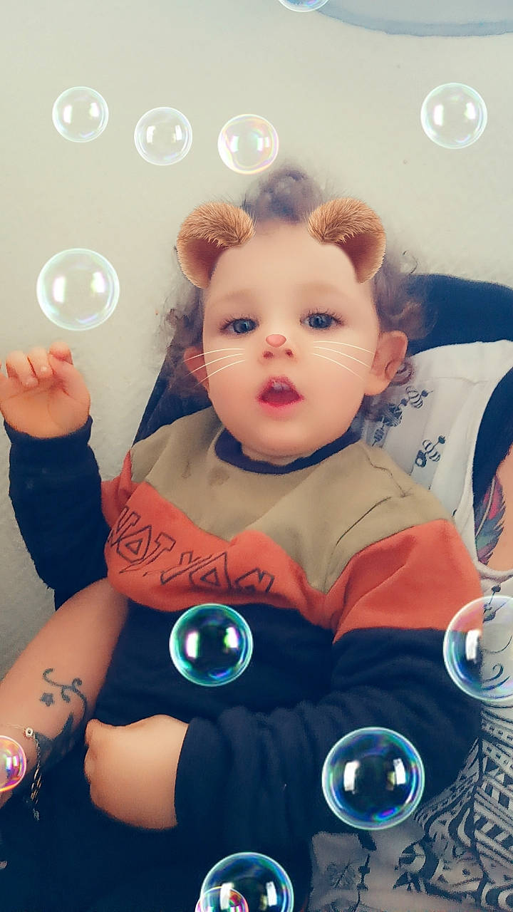 Emiliano a rejoint le concours — aidez-le/la à gagner de superbes lots ! arm, baby, baby_products, baby_toddler_clothing, child, electric_blue, fictional_character, fun, gesture, happy, nail, person, pink, room, selfie, sitting, skin, sleeve, stuffed_toy, surprise