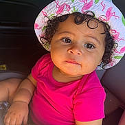 Harlo joined the competition — help win amazing prizes! toddler, child, baby, hat, flamingo, pink_shirt, curly_hair, car_seat, car_interior, window, greenery, sunlight, portrait, cute, young_child, person, indoors, summer, casual_clothing, closeup