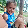 child, boy, smiling, portrait, outdoors, forest, woodland, picnic, bench, blue_shirt, camouflage_shorts, blond_hair, sitting, knees, nature, trees, daylight, candid, happy, family