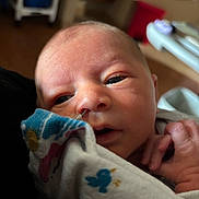 Easton joined the competition — help win amazing prizes! newborn, baby, infant, face, eyes, hand, blanket, clothing, skin, person, indoors, closeup, portrait, cute, young, resting, soft_light, hospital, cozy, wrapped