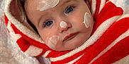 Michelle joined the competition — help win amazing prizes! baby, child, face, blue_eyes, cream, towel, striped, red, white, hood, skin_care, cute, infant, wrapped, portrait, lying_down, soft_surface, close_up, indoors, expression