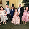 Selerina is registered to the contest to win money with this photo: children, formal_wear, dress, suit, group, indoor, posing, kids, party, event, smile, hair, shoes, carpet, plant, wall, restroom_sign, bow_tie, curly_hair, confident