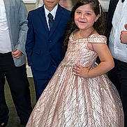 Selerina is registered to the contest to win money with this photo: child, boy, girl, formal_wear, suit, dress, party, event, posing, smile, indoor, carpet, people, adult, fashion, celebration, hair, face, hand_on_hip, confident