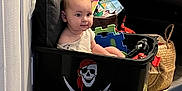 Mylan participe au concours pour gagner de l'argent avec cette photo : baby, basket, child, colorful, couch, curious, floor, foam_puzzle, furniture, home, indoor, pillow, pirate_symbol, play, room, seated, smile, storage_bin, toy, young_child