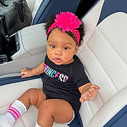 Gretchen joined the competition — help win amazing prizes! baby, black_shirt, bow, car, car_seat, child, curly_hair, cute, fashion, headband, indoors, infant, leather_seat, pink_flower, portrait, sitting, smiling, striped_socks, vehicle, white_socks
