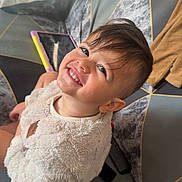 Ayden participe au concours pour gagner de l'argent avec cette photo : cheerful, child, couch, cozy, cute, face, fuzzy_clothing, geometric_pattern, happy, indoors, living_room, person, portrait, seated, short_hair, smiling, sweater, tablet, toddler, toy_tablet