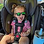 Oaklynne joined the competition — help win amazing prizes! toddler, child, car_seat, sunglasses, pink_shirt, safety_harness, car_interior, cup_holder, blue_cup, seatbelt, reflection, sunlight, hair_tied, window, tree_outside, vehicle, happy, open_mouth, casual, daytime