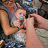 Hudson is registered to the contest to win money with this photo: baby, woman, indoor, blanket, glasses, pacifier, chick, hand, person, table, book, can, arm, chair, couch, decor, carpet, furniture, smile, curious