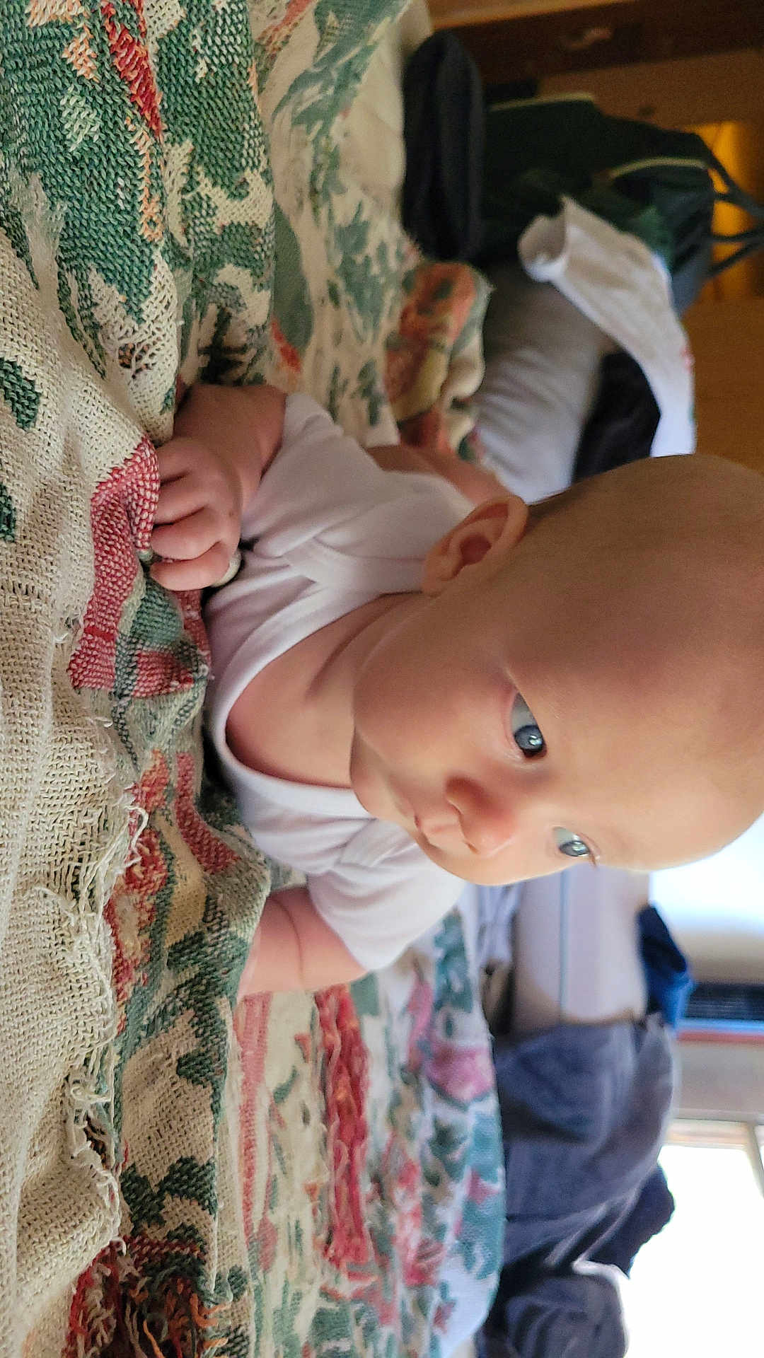 Spencer joined the competition — help win amazing prizes! baby, infant, child, onesie, blanket, patterned_blanket, indoor, blue_eyes, skin, head, face, hand, lying_down, curious, soft_light, cozy, person, toddler, closeup, portrait