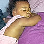 toddler, sleeping, child, blanket, purple, curly_hair, peaceful, nap, soft_lighting, indoor, close_up, skin, clothing, relaxing, cute, portrait, infant, resting, baby, cozy